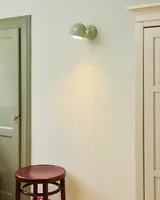 DC Væglampe Salviegrøn Ø12 fra Halo Design på en væg i en entré