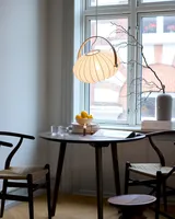 DC Textile Pendel Satinhvid fra Halo Design over et spisebord ved vinduet - blødt lys ved bordet